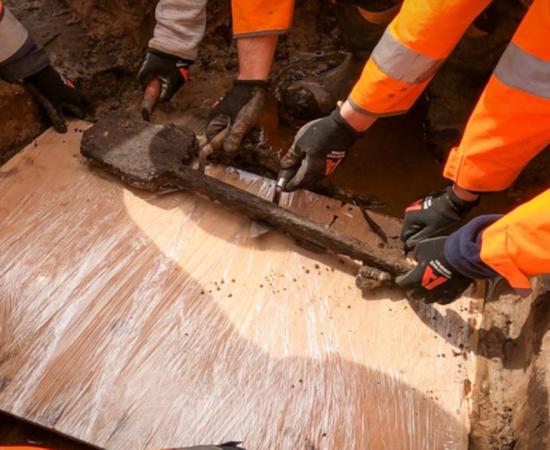 Archaeologists removiing the 3,500-year-old wooden spade from the finde site.